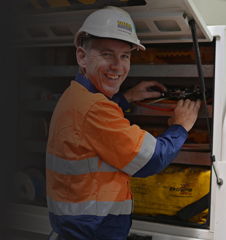 A staff smiling at the camera while looking for generator equipment